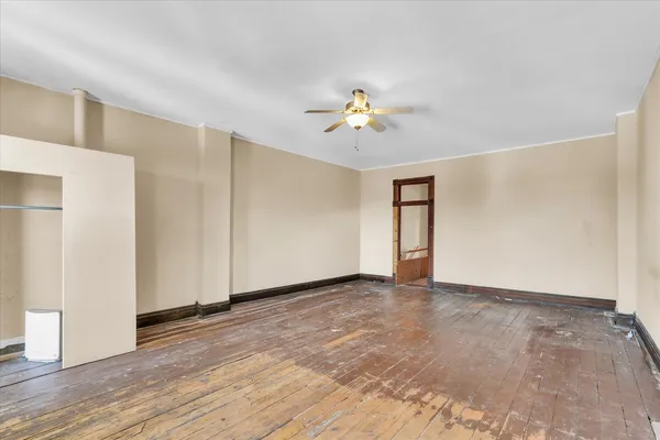a view of an empty room with closet and a window