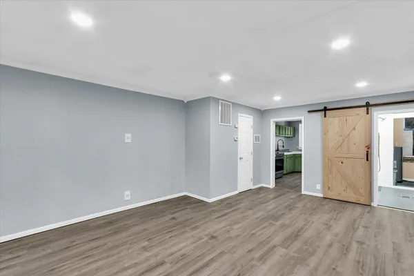 a view of an empty room with wooden floor