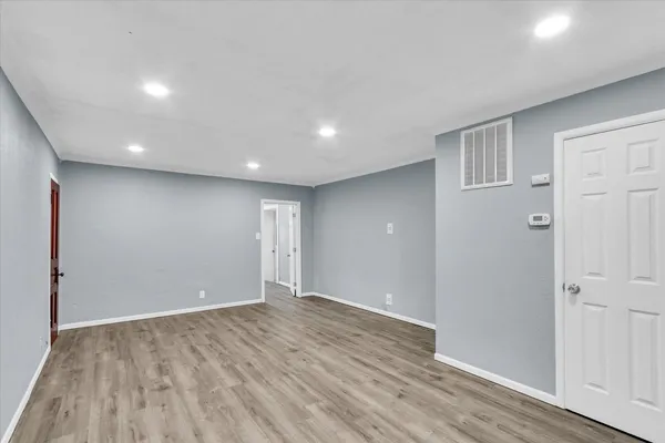 a view of an empty room with wooden floor