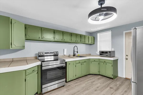a kitchen with a stove sink and cabinets