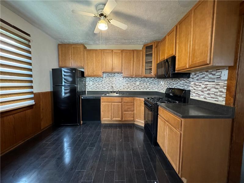 1012 11th Street McKees Rocks, PA 15136 - Photo 15 of 50 a kitchen with stainless steel appliances granite countertop a stove a refrigerator a sink dishwasher and a stove with wooden floor