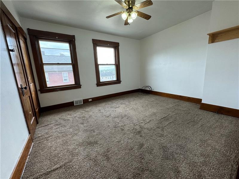 1012 11th Street McKees Rocks, PA 15136 - Photo 22 of 50 an empty room with windows and fan