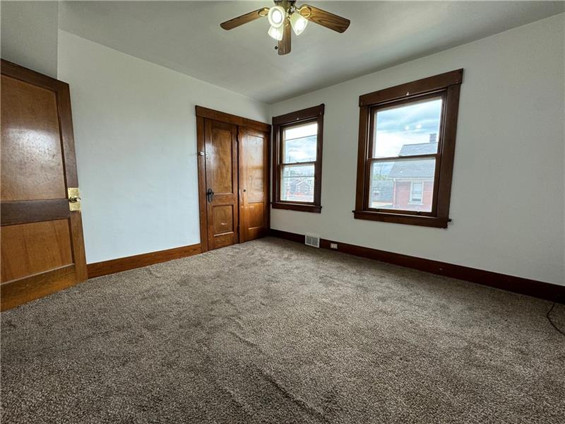 1012 11th Street McKees Rocks, PA 15136 - Photo 23 of 50 an empty room with chandelier fan and windows