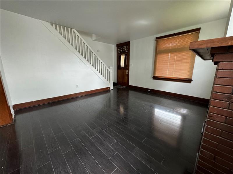 1012 11th Street McKees Rocks, PA 15136 - Photo 3 of 50 a view of an empty room with wooden floor and a window