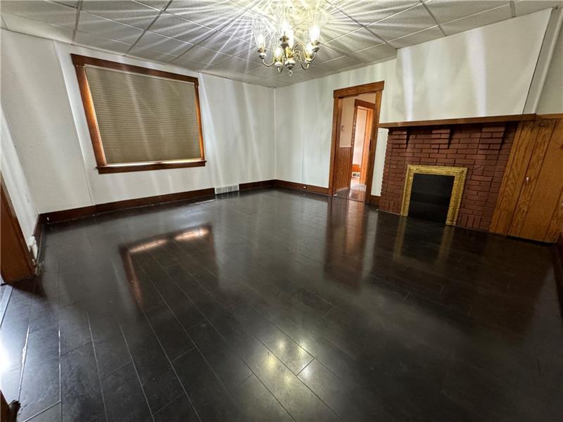 1012 11th Street McKees Rocks, PA 15136 - Photo 9 of 50 a view of an empty room with wooden floor and a window