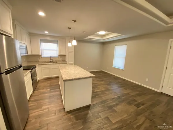 a kitchen with stainless steel appliances granite countertop a sink a stove a refrigerator and island