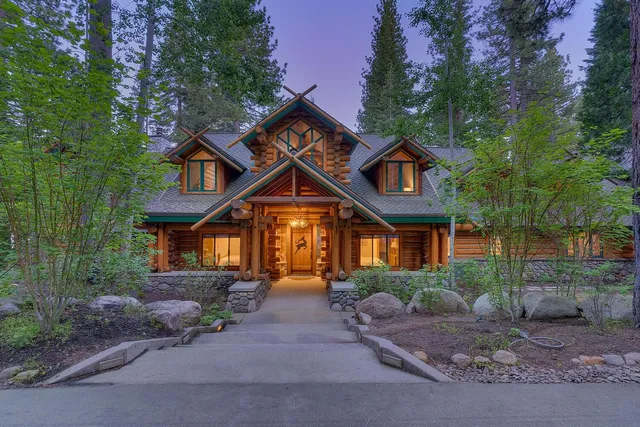 a front view of a house with a yard and trees