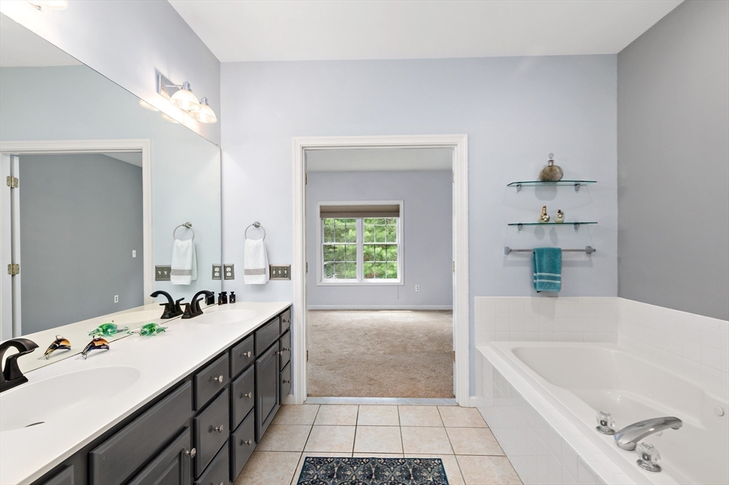 31 Fox Hollow Plymouth, MA 02360 - Photo 13 of 39 a bathroom with a tub a sink and a large mirror