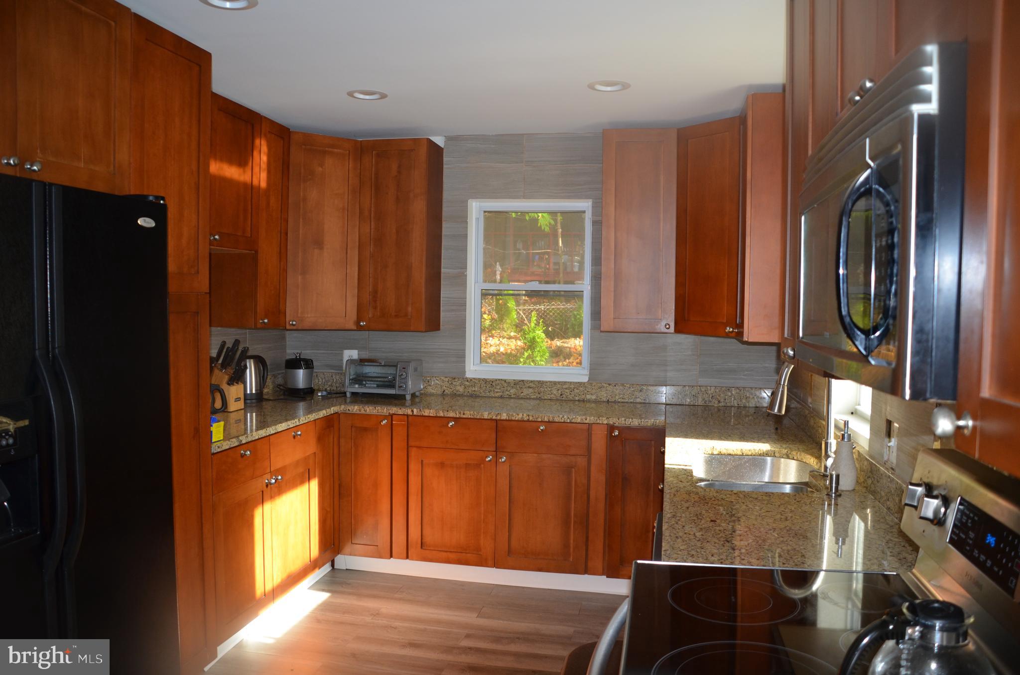 8709 Reading Road Silver Spring, MD 20901 - Photo 3 of 44 a kitchen with stainless steel appliances granite countertop a refrigerator and a sink