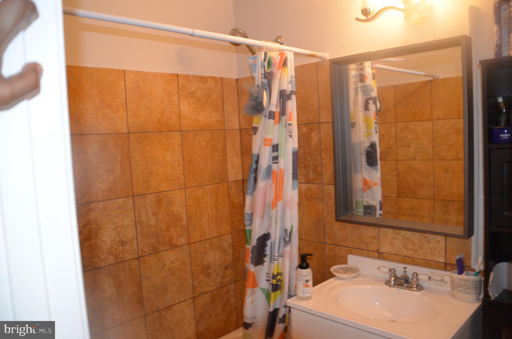 8709 Reading Road Silver Spring, MD 20901 - Photo 7 of 44 a bathroom with a sink and a mirror