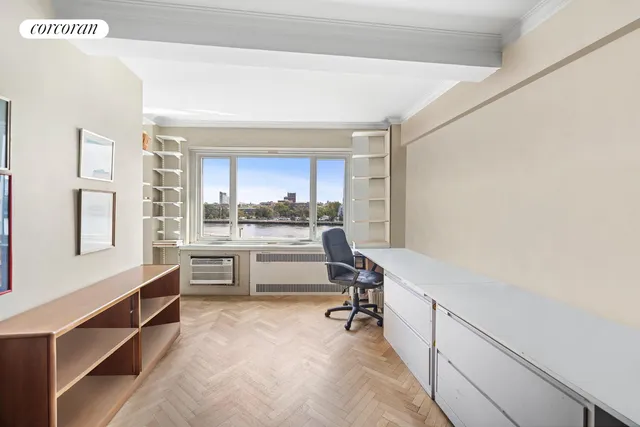 a spacious bedroom with a bed a chandelier and a bookshelf