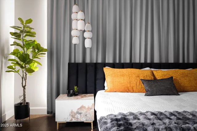 a bedroom with a bed dresser and a chandelier