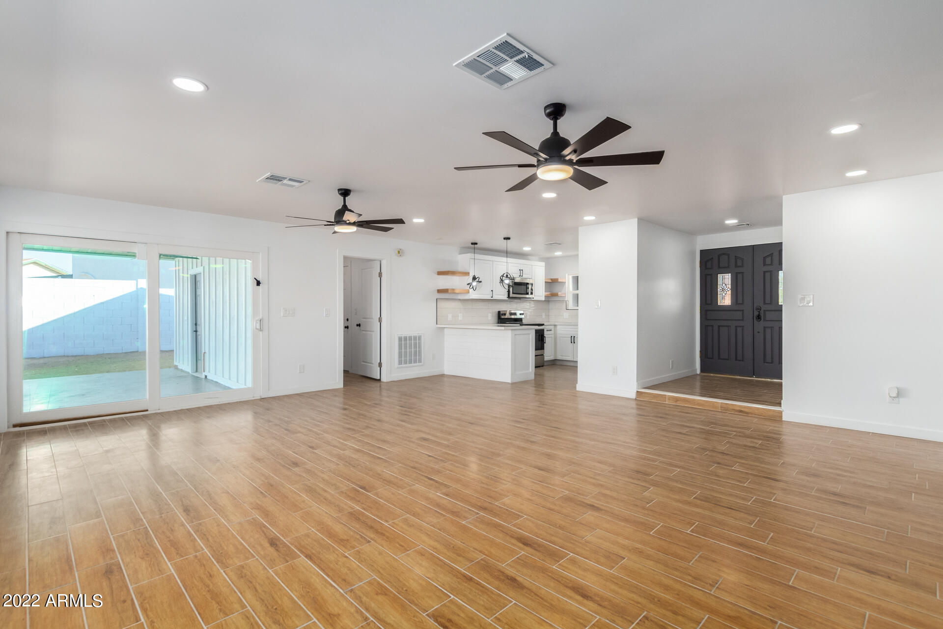 4110 East Vineyard Road Phoenix, AZ 85042 - Photo 14 of 31 a view of a big room with wooden floor and a ceiling fan