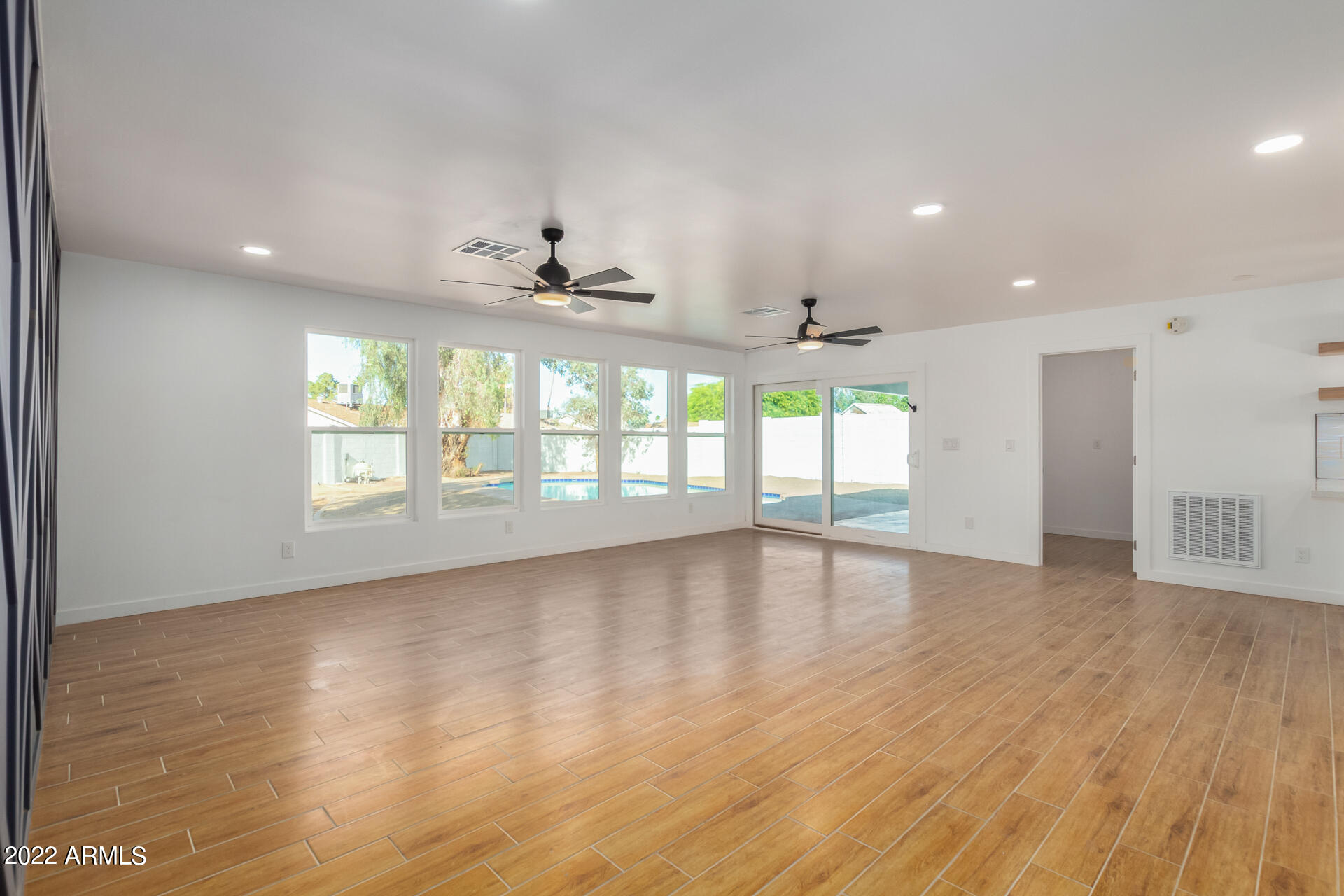 4110 East Vineyard Road Phoenix, AZ 85042 - Photo 15 of 31 an empty room with wooden floor and windows