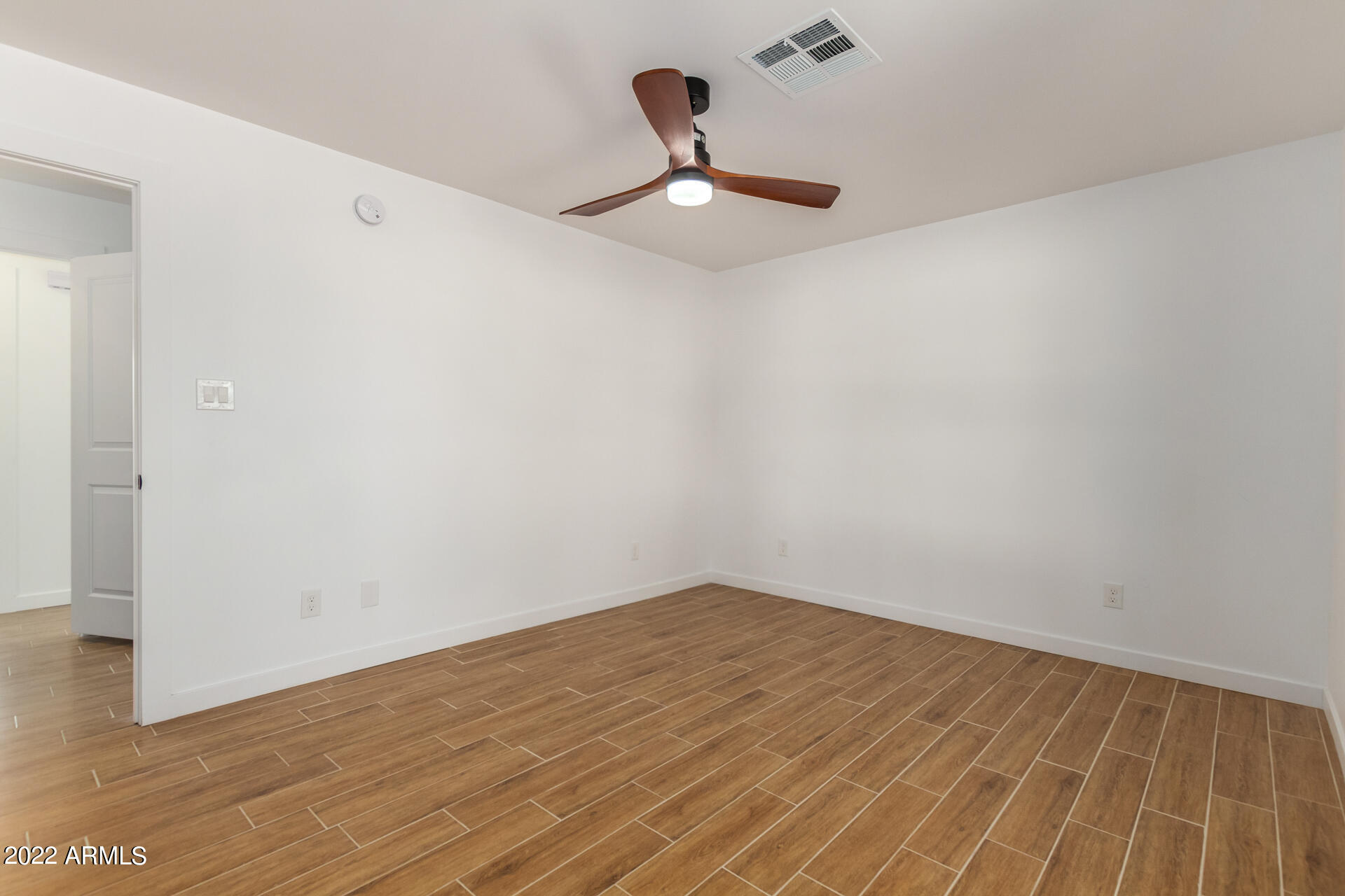 4110 East Vineyard Road Phoenix, AZ 85042 - Photo 17 of 31 a view of a room with wooden floor and a ceiling fan
