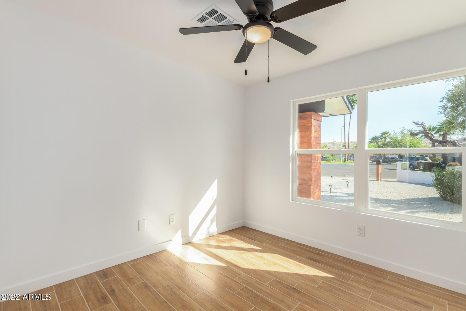 4110 East Vineyard Road Phoenix, AZ 85042 - Photo 23 of 31 wooden floor in an empty room with a window