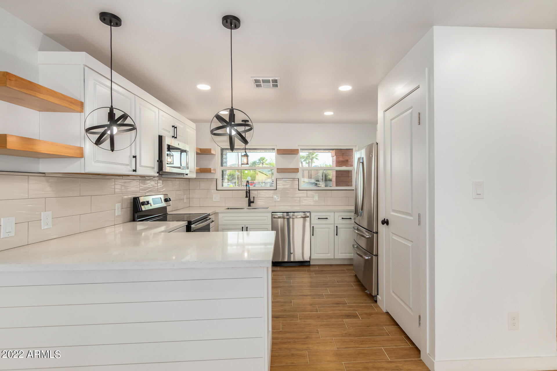 4110 East Vineyard Road Phoenix, AZ 85042 - Photo 9 of 31 a open kitchen with stainless steel appliances granite countertop a sink a refrigerator and window