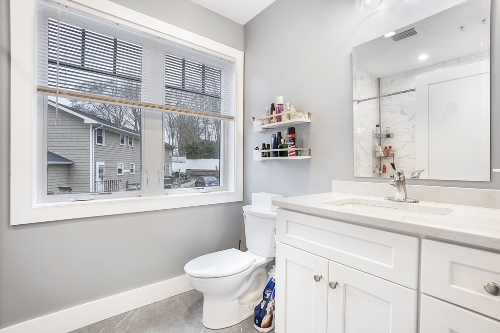 245 Bussey Street, Unit 205 Dedham, MA 02026 - Photo 15 of 17 a bathroom with a granite countertop sink mirror vanity and toilet