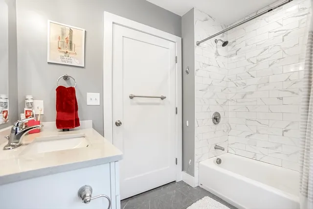 a bathroom with a tub sink and mirror