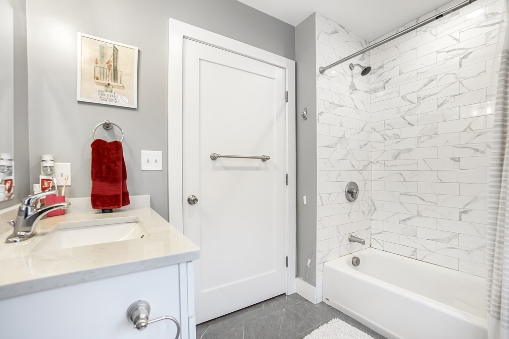 245 Bussey Street, Unit 205 Dedham, MA 02026 - Photo 16 of 17 a bathroom with a tub sink and mirror