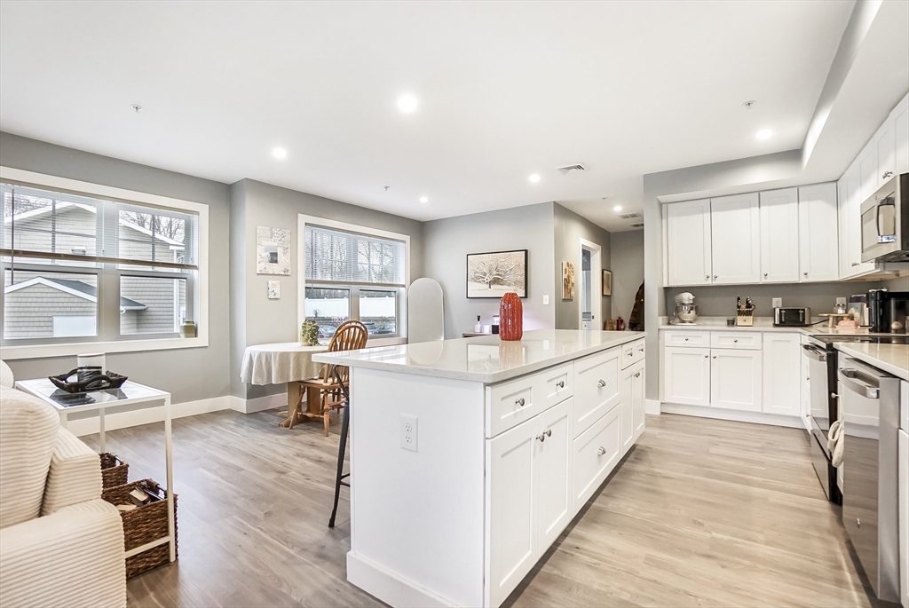 245 Bussey Street, Unit 205 Dedham, MA 02026 - Photo 3 of 17 a kitchen with white cabinets and sink