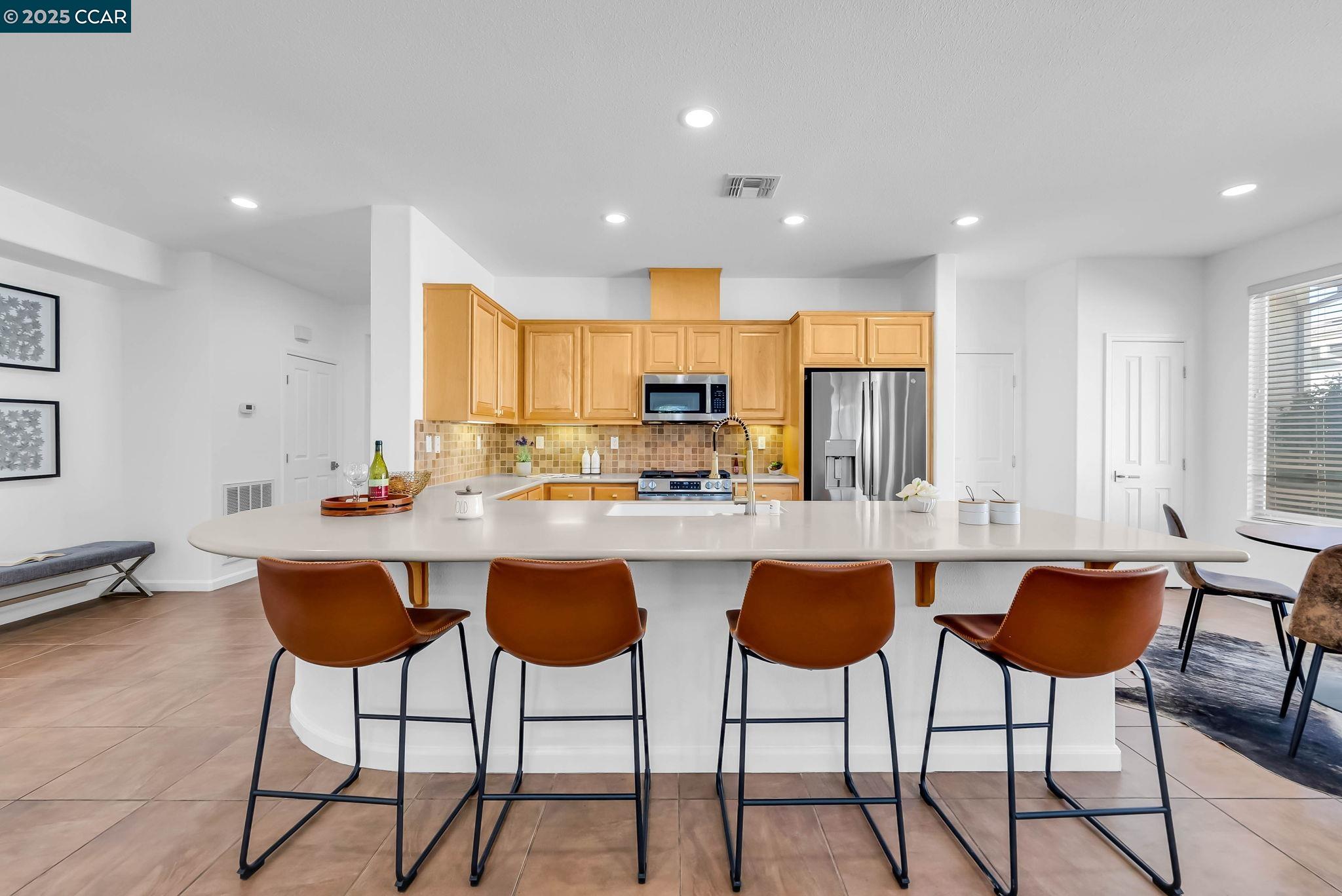 900 Brookside Lane Rio Vista, CA 94571 - Photo 20 of 60 a kitchen with stainless steel appliances kitchen island granite countertop a stove a sink a refrigerator with white cabinets and chairs