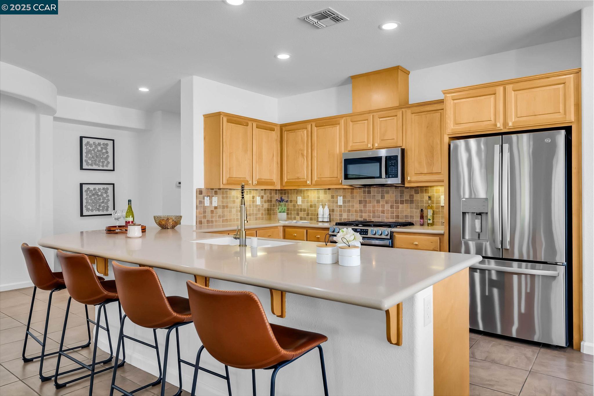 900 Brookside Lane Rio Vista, CA 94571 - Photo 21 of 60 a kitchen with granite countertop a table chairs microwave and refrigerator
