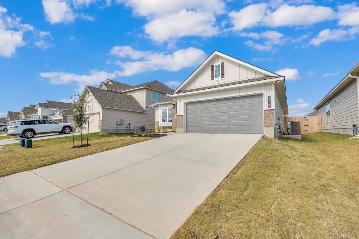 151 Timbo Drive Jarrell, TX 76537 - Photo 1 of 1 Craftsman-style house with board and batten siding, a garage, a front lawn, and concrete driveway