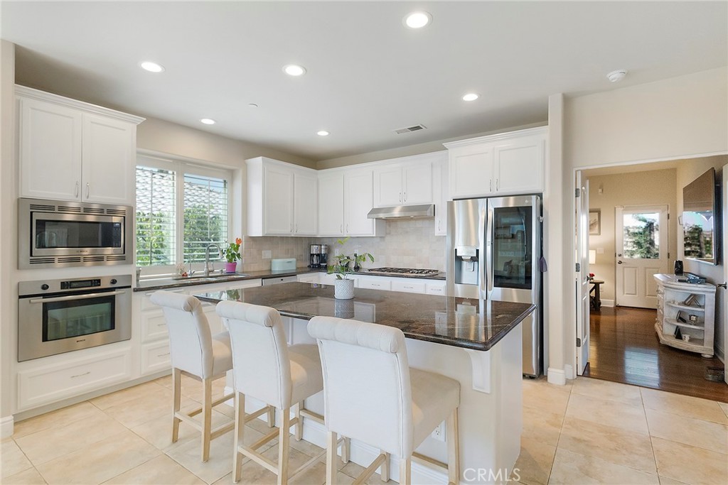 3294 Summit Ridge Terrace Chico, CA 95928 - Photo 15 of 68 a kitchen with stainless steel appliances granite countertop a stove a sink a refrigerator a microwave oven with a dining table and chairs