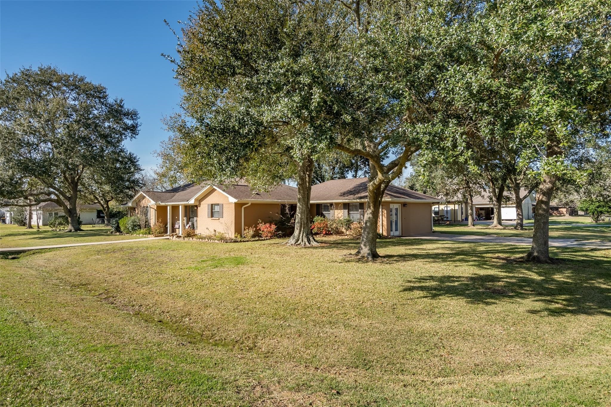 105 Alice Street Anahuac, TX 77514 - Photo 1 of 39 a big house with trees in front of it