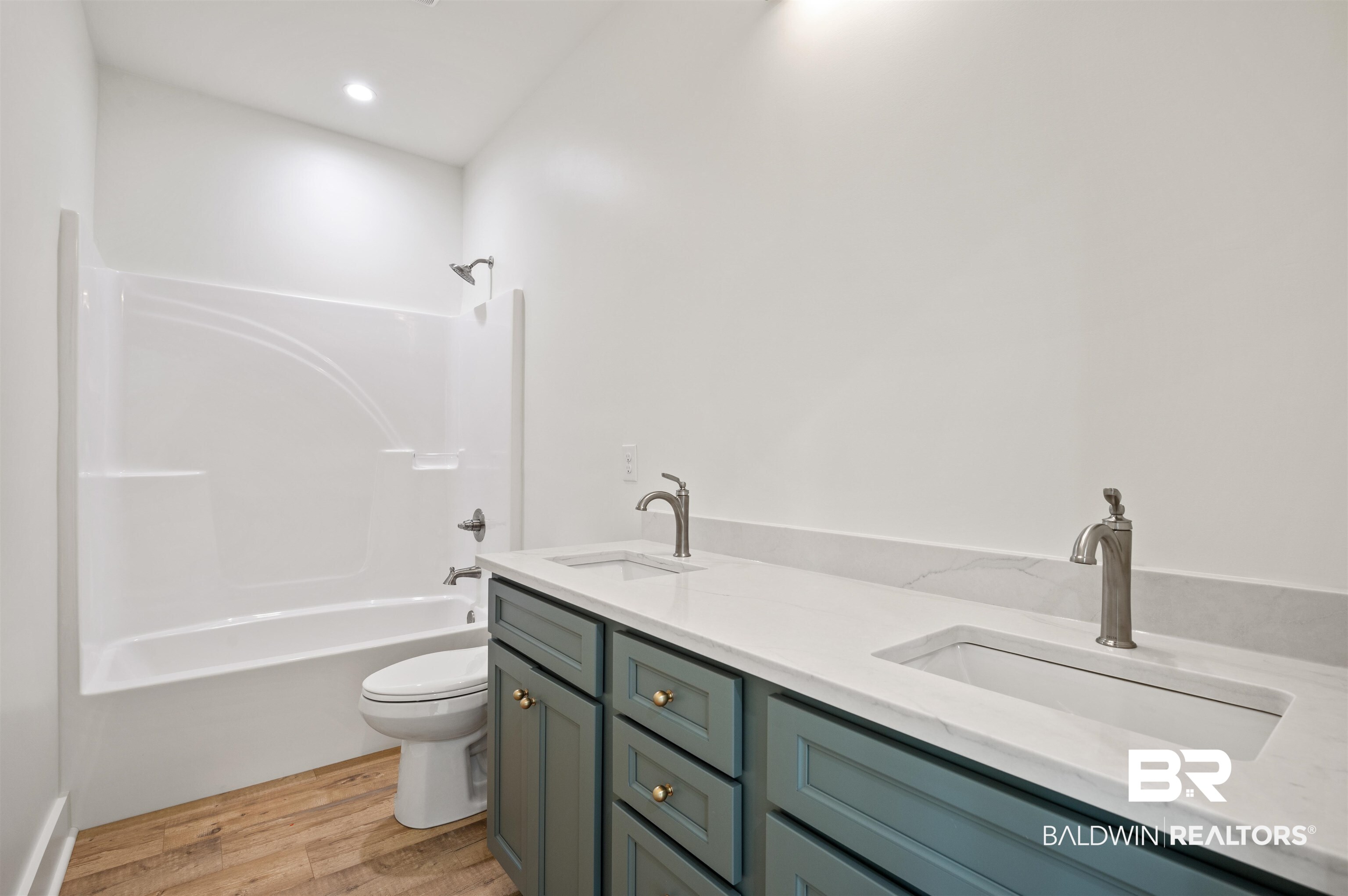 657 Island Way Gulf Shores, AL 36542 - Photo 33 of 59 Bathroom with toilet, wood finished floors, double vanity, and washtub / shower combination