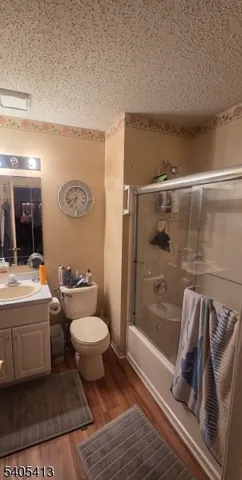 a view of a hallway with wooden floor and cabinets