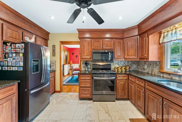 a large kitchen with cabinets chairs and stainless steel appliances