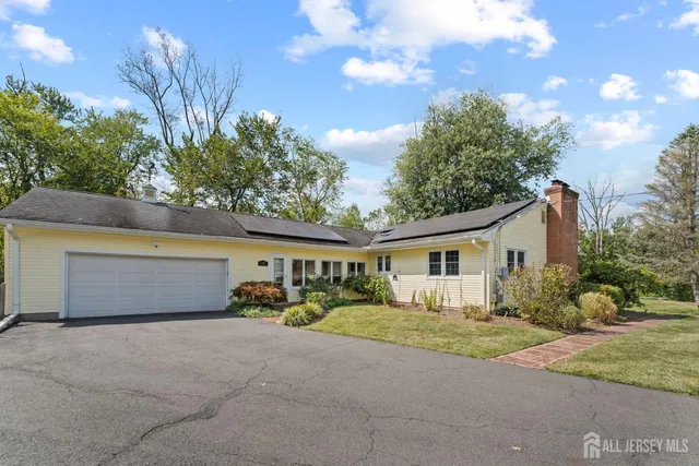 a view of house with yard and trees in the background