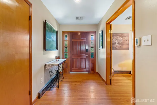 a view of a hallway with wooden floor and windows