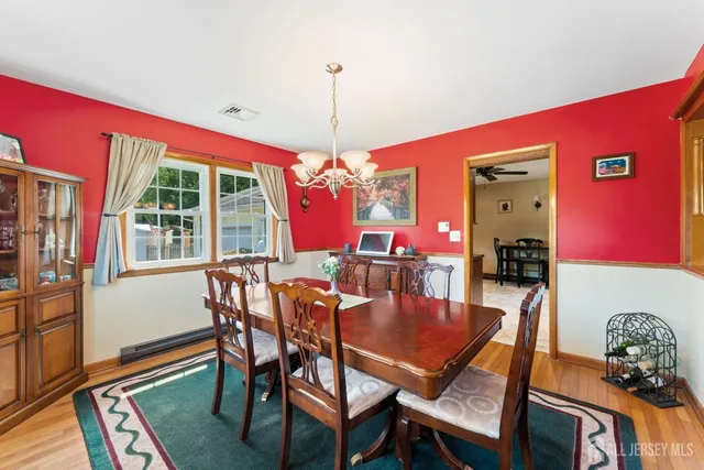 a dining room with furniture a chandelier and wooden floor