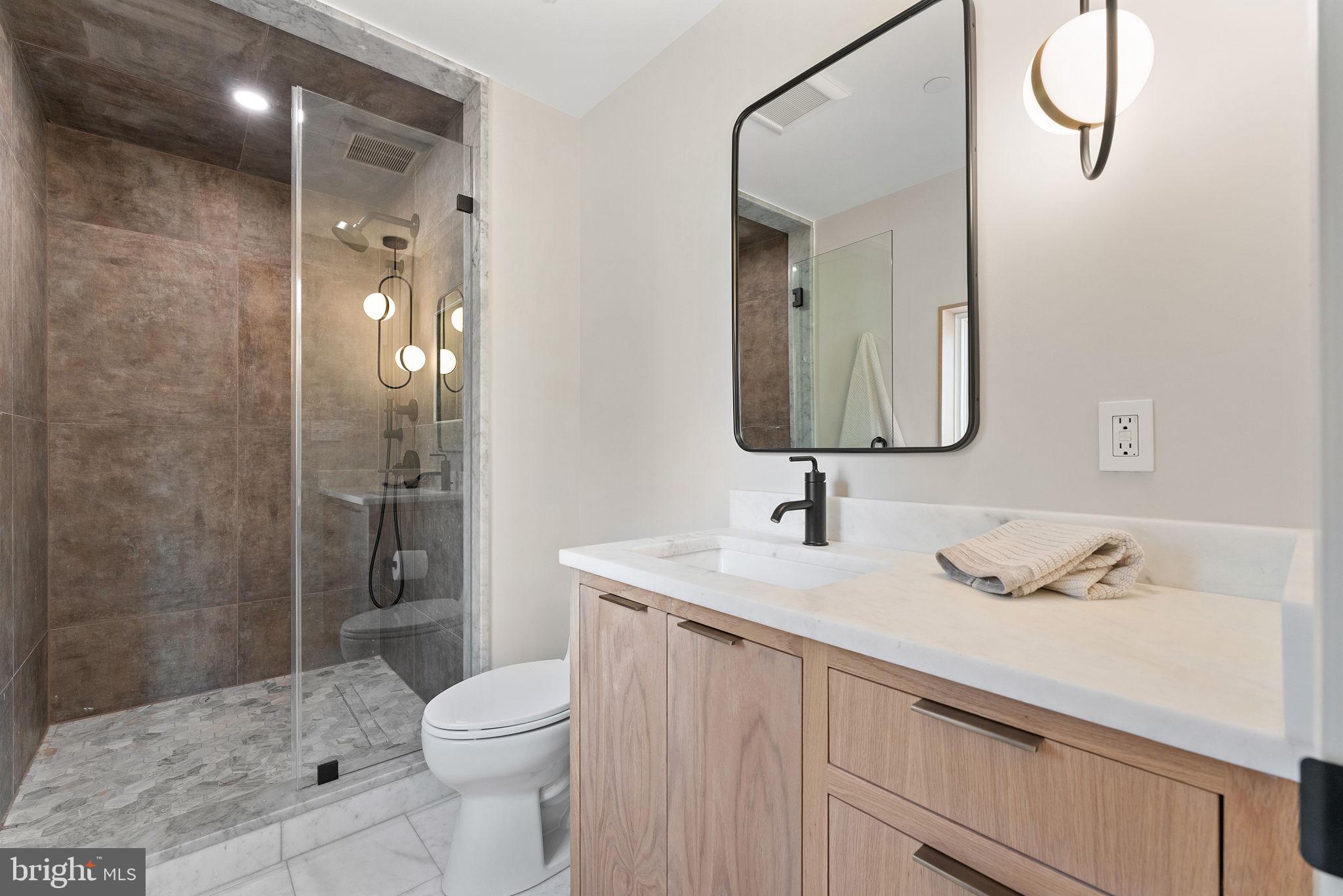 21 Overbeck Alley Northeast Washington, DC 20002 - Photo 39 of 63 a bathroom with a sink toilet vanity and shower