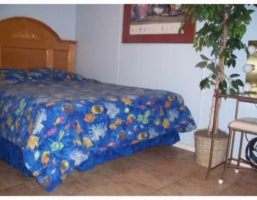 a bedroom with a bed and a potted plant