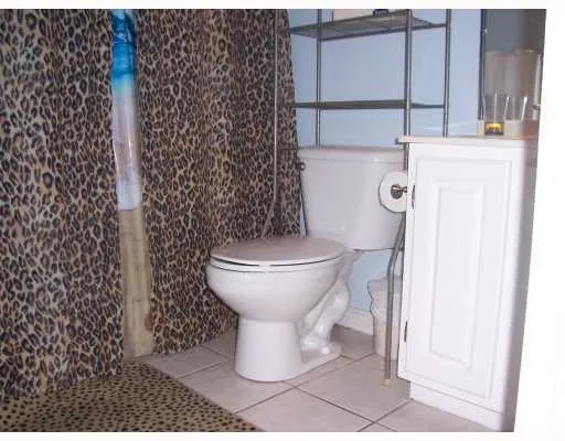 a bathroom with a toilet and a shower curtain