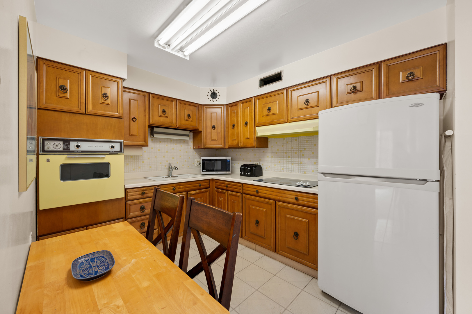 5855 North Sheridan Road, Unit 10G Chicago, IL 60660 - Photo 10 of 31 a kitchen with a refrigerator a stove a sink and white cabinets