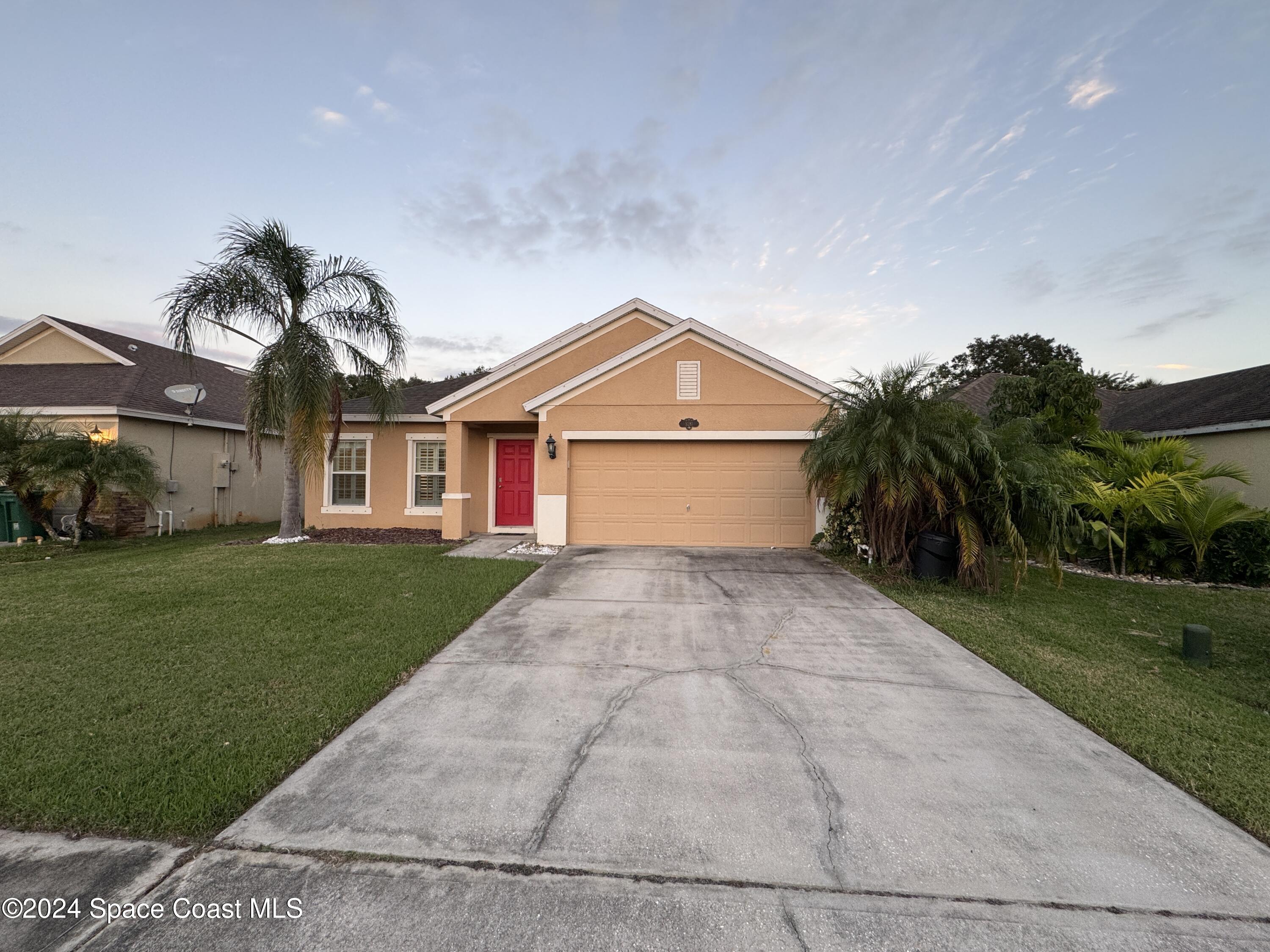 5281 Talbot Boulevard Cocoa, FL 32926 - Photo 1 of 31 a front view of a house with a yard and garage