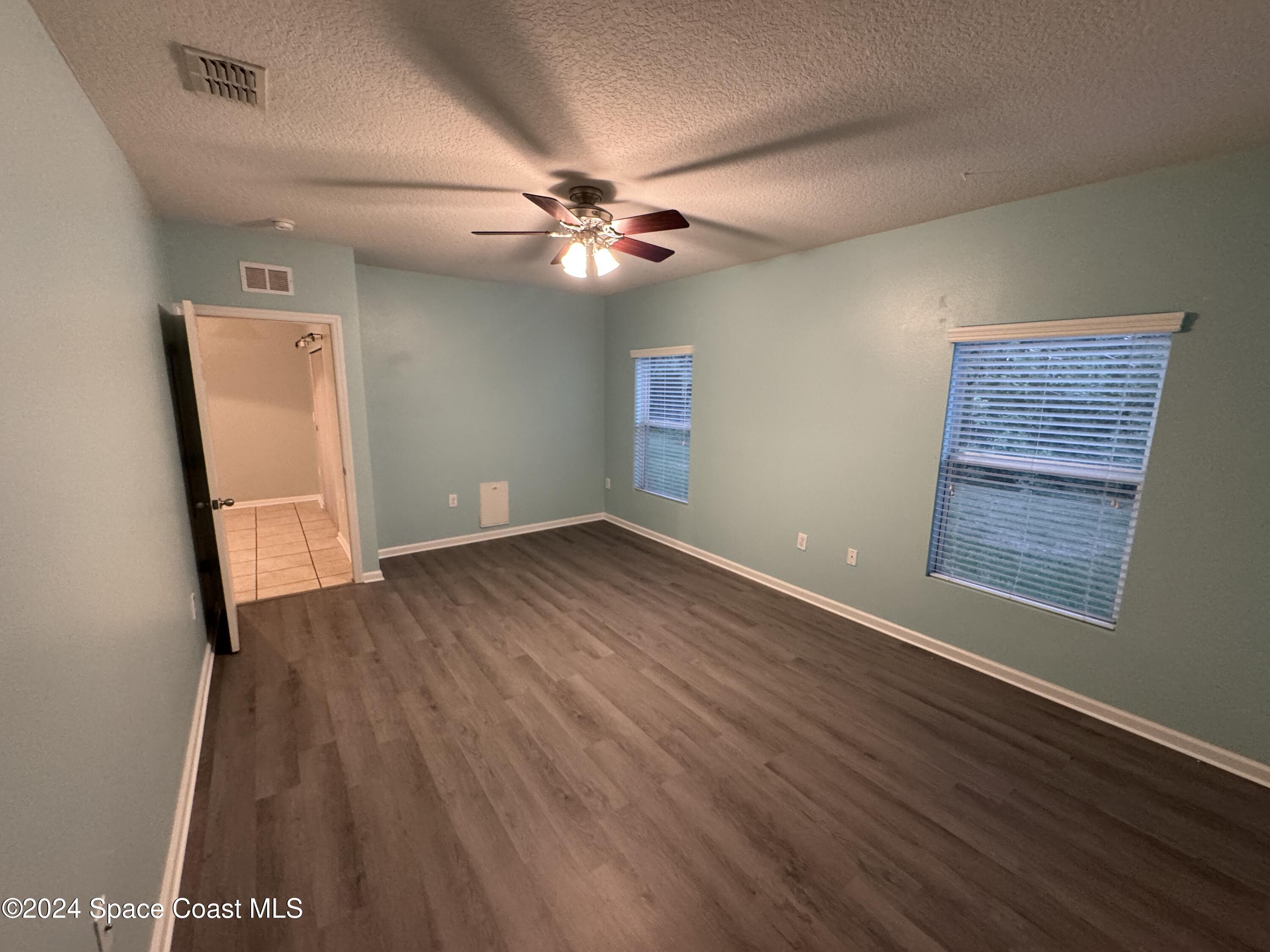 5281 Talbot Boulevard Cocoa, FL 32926 - Photo 15 of 31 an empty room with wooden floor fan and windows