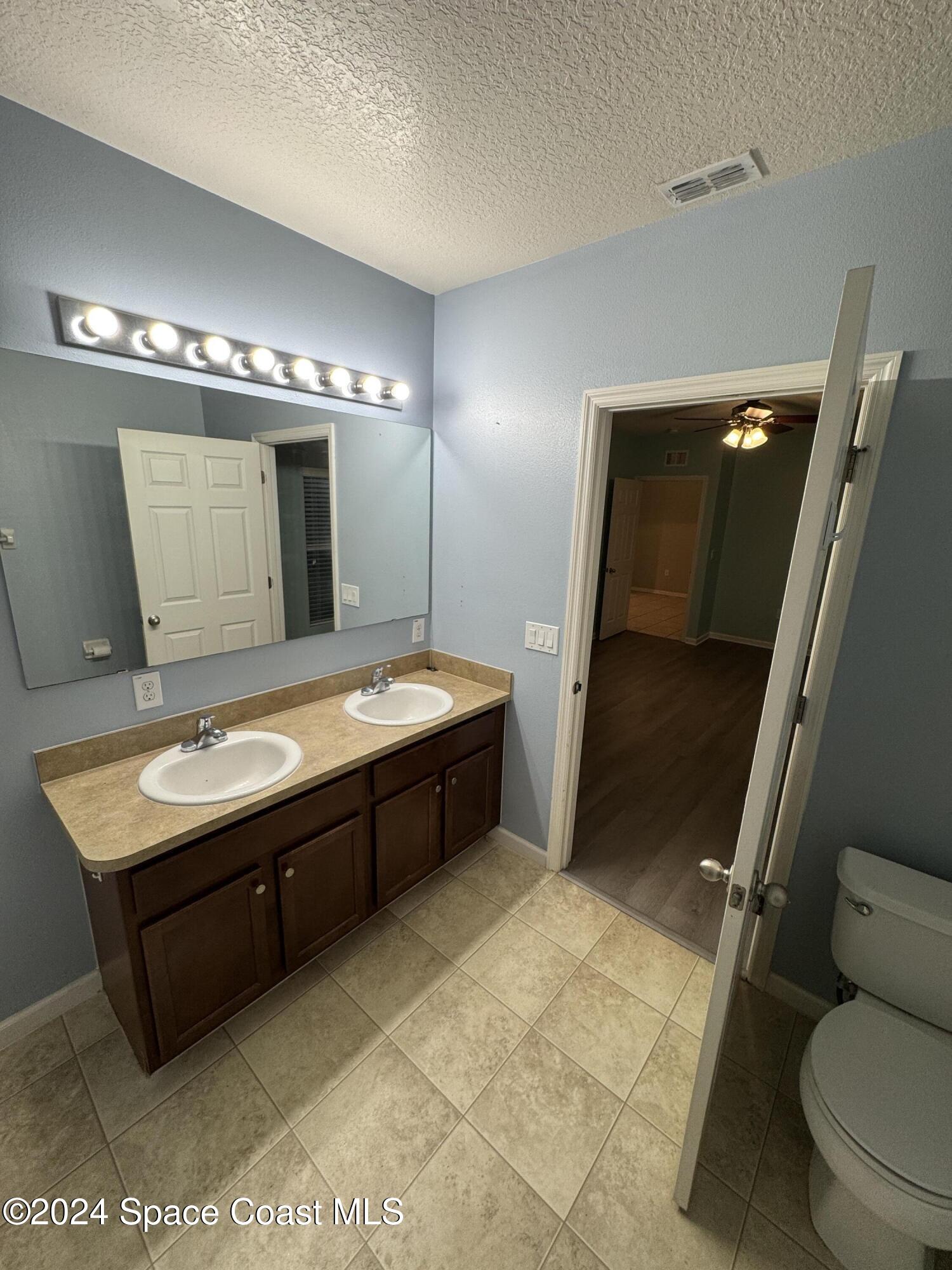 5281 Talbot Boulevard Cocoa, FL 32926 - Photo 19 of 31 a bathroom with a sink mirror vanity and toilet