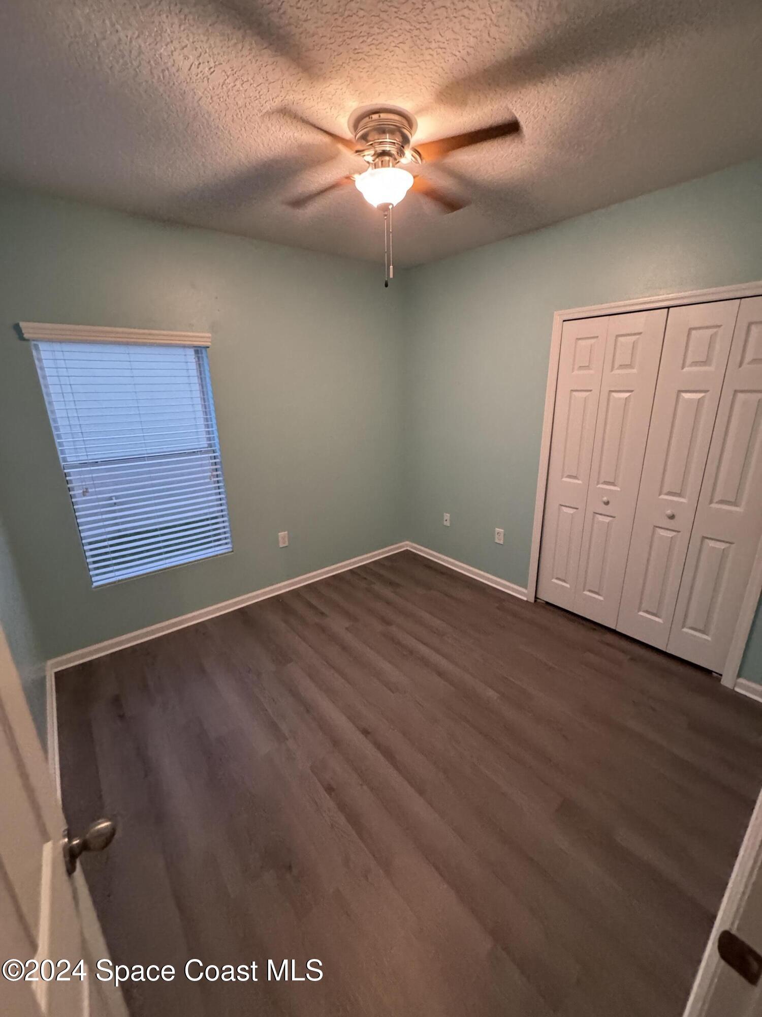 5281 Talbot Boulevard Cocoa, FL 32926 - Photo 20 of 31 an empty room with wooden floor and fan