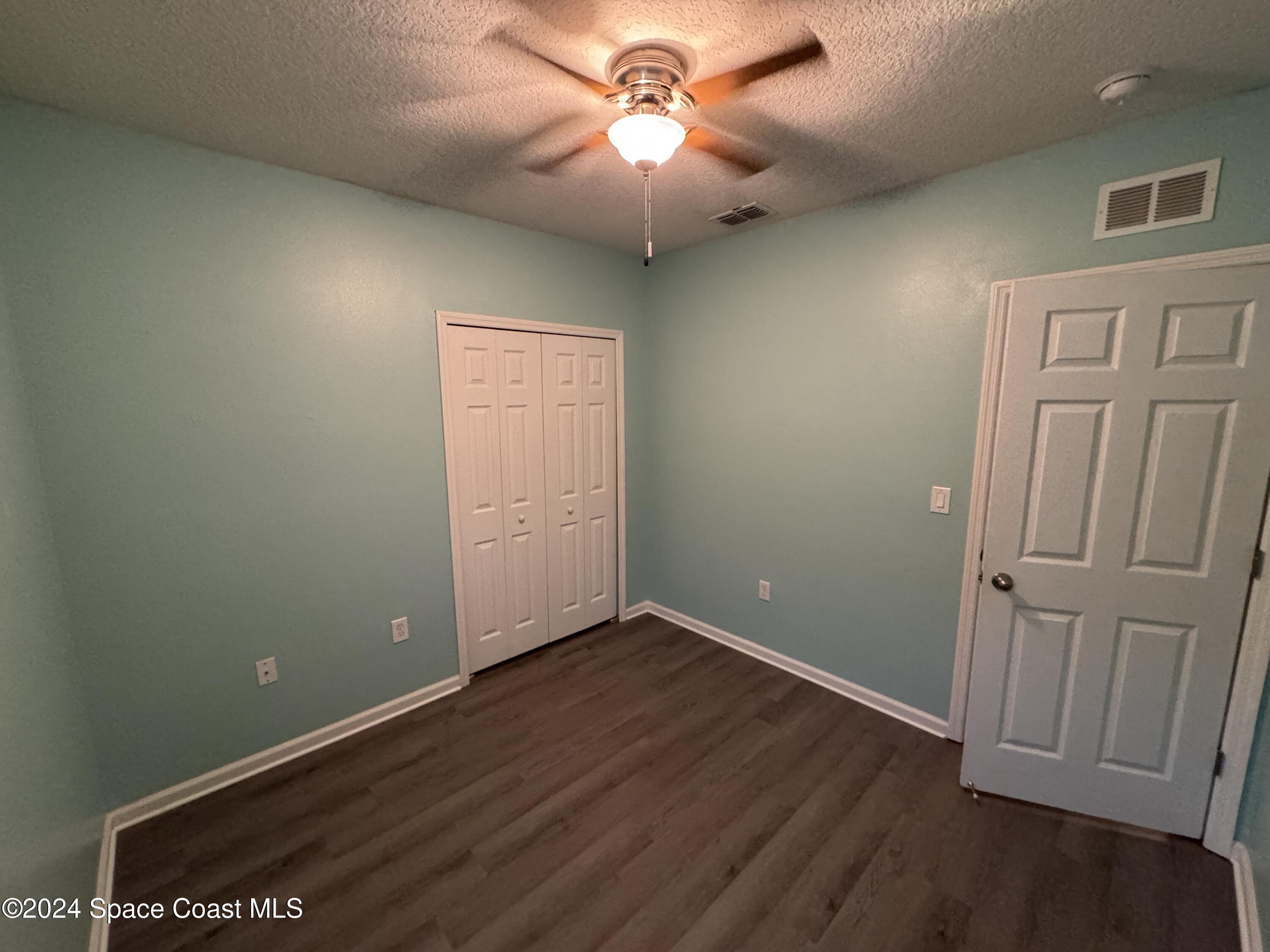 5281 Talbot Boulevard Cocoa, FL 32926 - Photo 21 of 31 an empty room with wooden floor and a ceiling fan