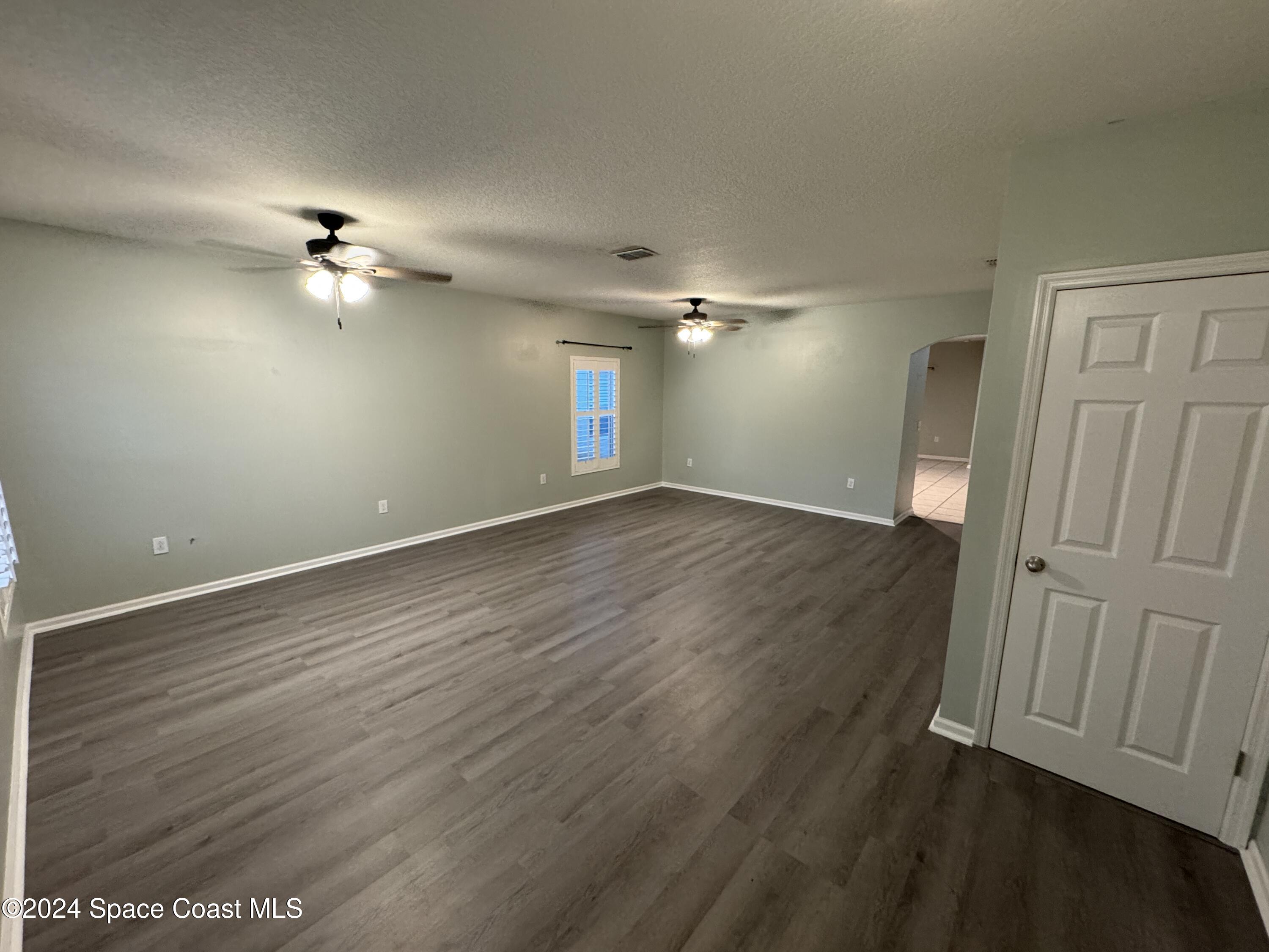 5281 Talbot Boulevard Cocoa, FL 32926 - Photo 4 of 31 wooden floor in an empty room with a window