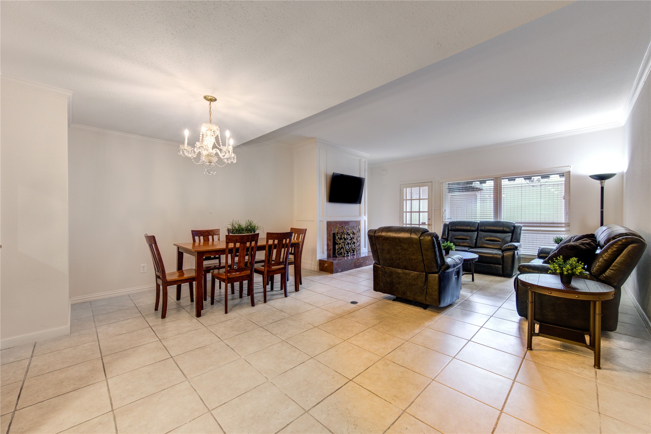 2232 South Piney Point Road, Unit 110 Houston, TX 77063 - Photo 8 of 21 Bright and spacious open-concept living and dining area with elegant crown molding, oversized tile flooring, and plenty of room to entertain in comfort and style.