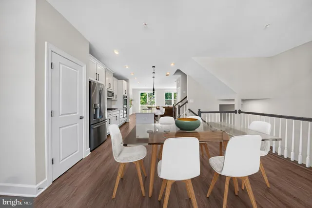 a view of a kitchen with wooden floor electronic appliances and stairs