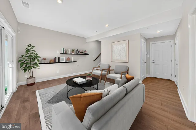 a living room with furniture and a wooden floor