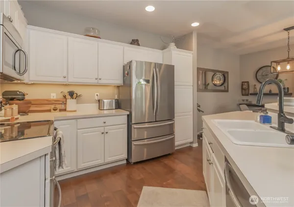 a kitchen with a sink a stove a refrigerator and cabinets